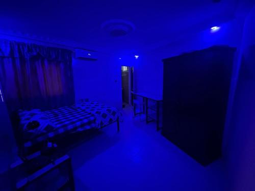 a blue room with a bed and a table in it at Welcom family in Saint-Louis