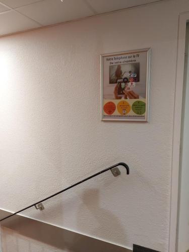 a picture hanging on a wall in a bathroom at Premiere Classe Arras - Tilloy Les Mofflaine in Tilloy-lès-Mofflaines