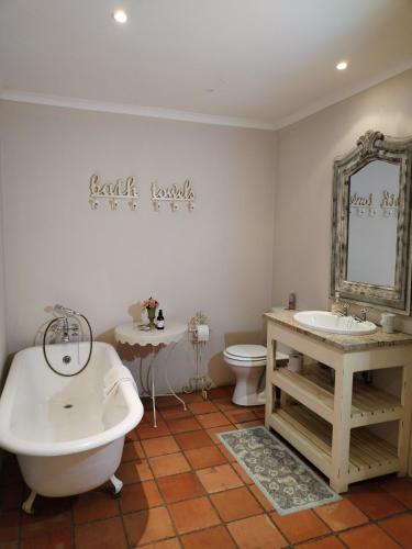 a bathroom with a tub and a sink and a toilet at The Glades Cottage in Balgowan