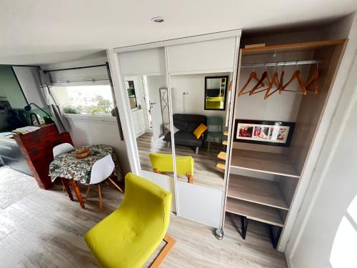 un salon avec une chaise jaune et une table dans l'établissement Pause relax à Mont de Marsan, à Mont-de-Marsan