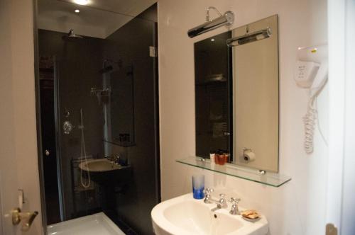 a bathroom with a sink and a shower and a mirror at Relais Teatro Argentina in Rome