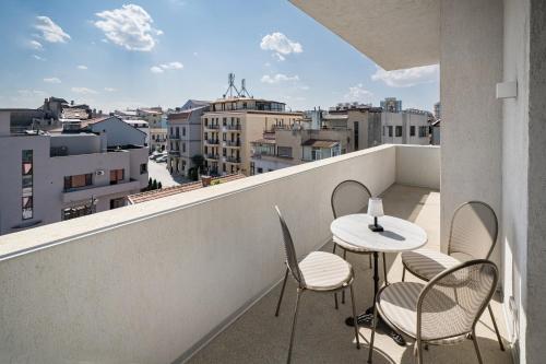 a balcony with a table and chairs and a view at Rezident Tomis Marina in Constanţa