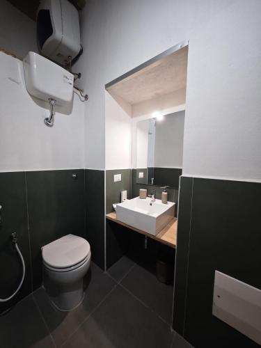 a bathroom with a white toilet and a sink at Monolocale Zena in Carloforte