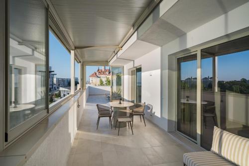a balcony with a table and chairs and windows at Rezident Tomis Marina in Constanţa