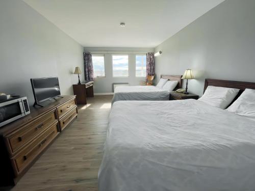 a hotel room with two beds and a flat screen tv at Ramada by Wyndham Florenceville in Florenceville