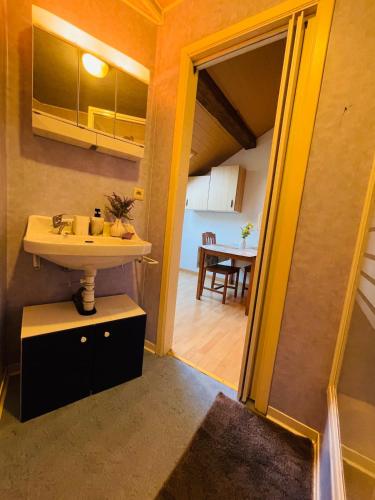 a bathroom with a sink and a dining room at Appartement rustique à Liège in Liège