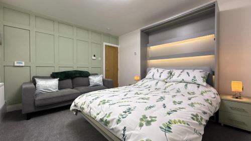 a bedroom with a large bed and a couch at Barmouth Beach Ground Floor Studio in Barmouth