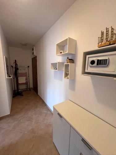 a kitchen with a counter and a microwave on a wall at Apartments "Helios" in Njivice