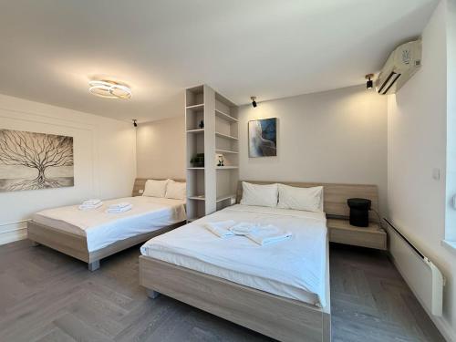 two beds in a room with white walls at Skadarlija Soul in Želenička Stanica Beograd Sava