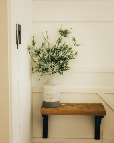 a vase of flowers sitting on a wooden shelf at The Duck Pond Cabin in Ryal