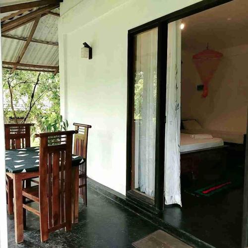 a room with a table and chairs and a window at Dambulla Sun Vsh Holiday in Dambulla