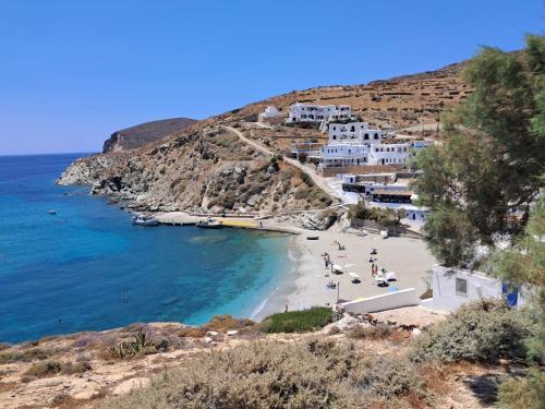a beach with a group of people sitting on the sand at CASA GIGLIO Folegandros in Agali