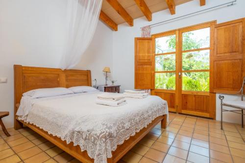 a bedroom with a bed and a large window at Ses Planes -Ca Na Faustina- in Selva