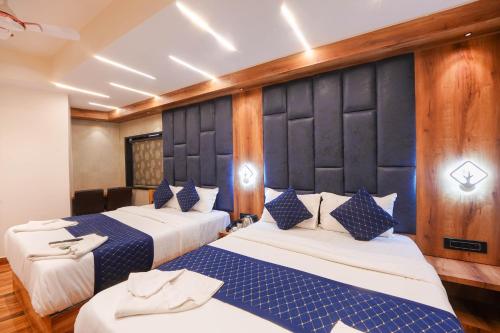 two beds in a room with blue and white at Hotel Prince Palace in Mumbai