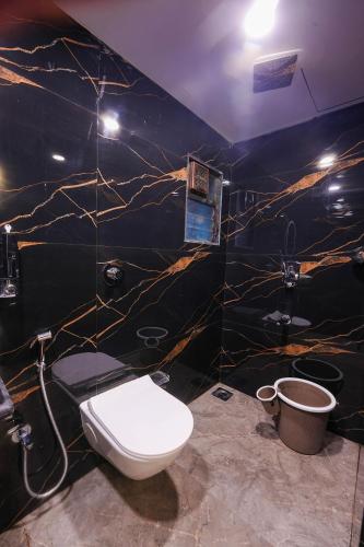 a bathroom with a toilet and a sink at Hotel Prince Palace in Mumbai