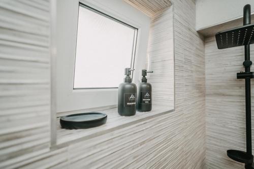 a bathroom with two bottles on a wall at A&Zs Residence in Gheorgheni