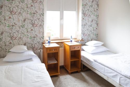 two twin beds in a room with a window at Mleczarnia Hotel Restauracja in Chludowo