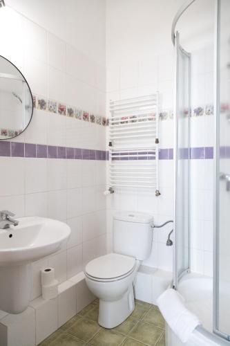 a white bathroom with a toilet and a sink at Mleczarnia Hotel Restauracja in Chludowo