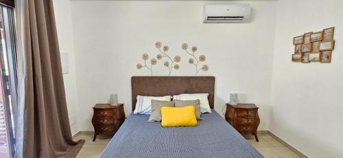 a bedroom with a bed with a yellow pillow on it at Villa Maria in Trani