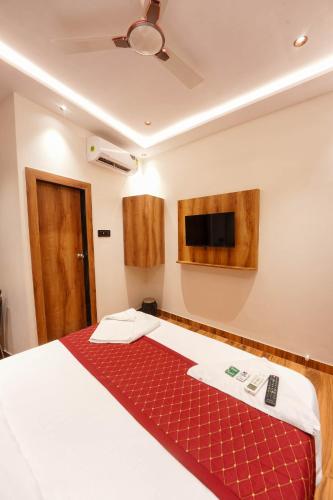 a bedroom with a bed and a tv on the wall at Hotel Prince Palace in Mumbai
