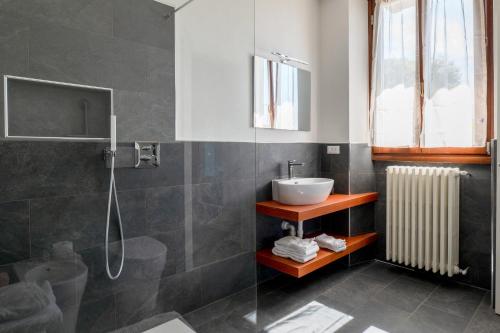 a bathroom with a sink and a shower at Casa 24 - Trilocale con Vista Lago, Giardino e Idromassaggio Gonfiabile in Arizzano
