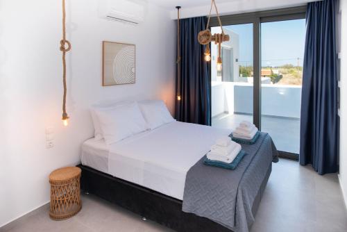 a bedroom with a bed and a large window at Mediterranean Blue Suites & Villa - Blue Horizon Suite in Tympáki