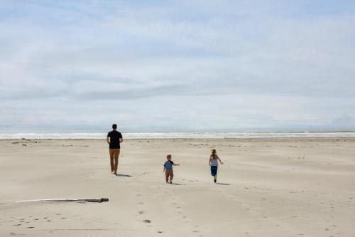 a man and two children walking on the beach at Breakwater Resort in Grayland