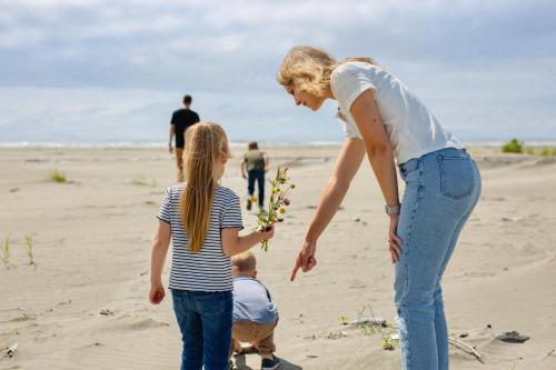a woman and two children playing on the beach at Breakwater Resort in Grayland