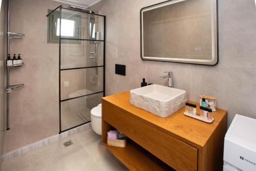 a bathroom with a sink and a shower at Mediterranean Blue Suites & Villa - Blue Horizon Suite in Tympáki