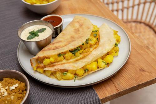 a white plate with a sandwich with corn salsa at Pearl Palace 4-Bedrooms Villa by Spacez with Private Theatre & Terrace in Mumbai