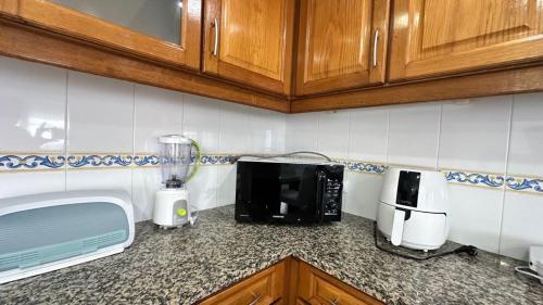a kitchen counter with a microwave and a blender at RIVABeach House in Lourinhã