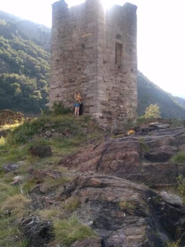 a person standing in front of a tower on a mountain at La Tór Appartamenti - Pramotton in Donnas