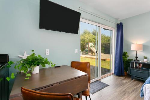 a living room with a table and a television on the wall at Breakwater Resort in Grayland