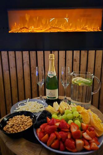 a table with a plate of fruit and a bottle of wine at Wellness Plus in Hrabŭvka