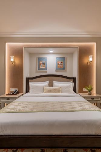 a bedroom with a large bed with two tables at The Residency - A Boutique Hotel in Jodhpur
