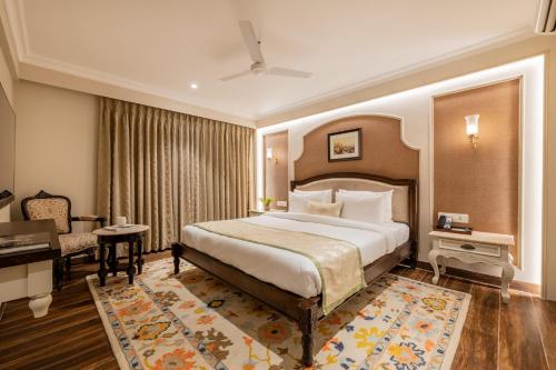 a hotel room with a large bed and a desk at The Residency - A Boutique Hotel in Jodhpur