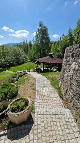 a stone pathway with a picnic table in a park at Hotel Karolinka in Karpacz