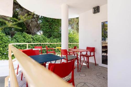 a patio with red chairs and tables on a patio at Villa Mar Rompido in El Rompido
