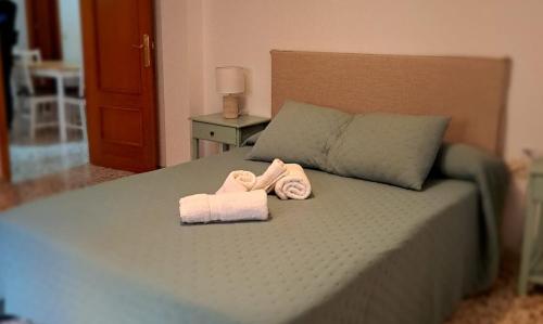 a bedroom with a bed with two towels on it at 5 Apartamentos Cómodos en el Corazón de Baza in Baza