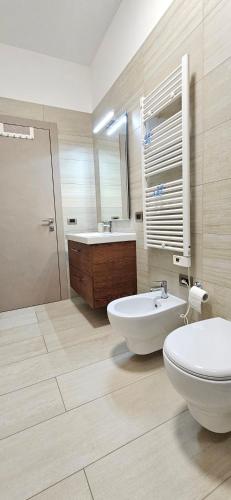 a bathroom with a toilet and a tub and a sink at Villa Maria in Trani