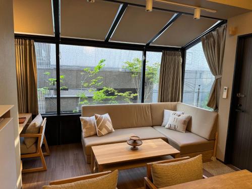 a living room with a couch and a table at Comforts81 DOTONBORI in Osaka