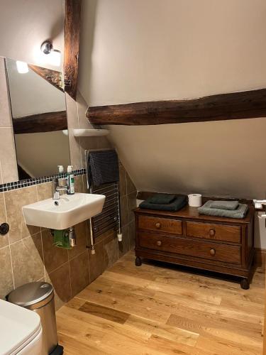 a bathroom with a sink and a mirror at Rooftops Loft in Hay-on-Wye