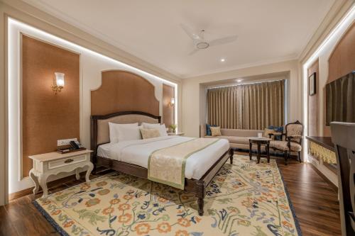 a bedroom with a large bed and a living room at The Residency - A Boutique Hotel in Jodhpur
