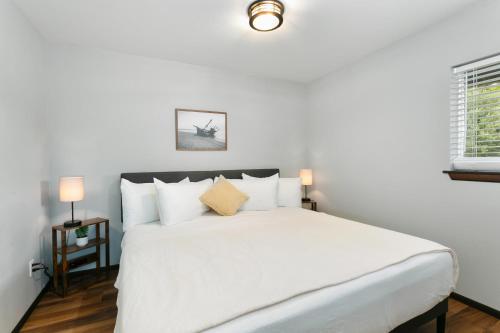 a bedroom with a large white bed with white pillows at Breakwater Resort in Grayland