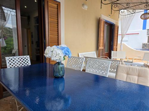een blauwe tafel met een vaas met bloemen erop bij Bedda Mia - Lipari in Lipari
