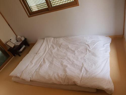 a white bed in a room with a window at SiEunJae in Gyeongju