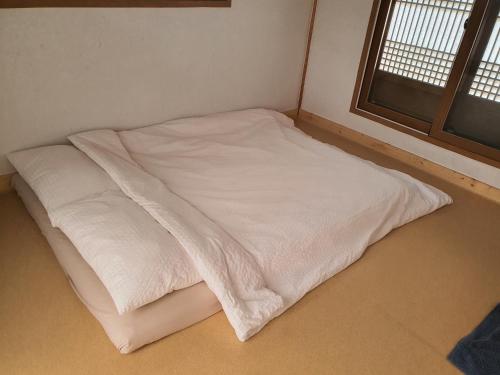 a white bed in a room with a window at SiEunJae in Gyeongju