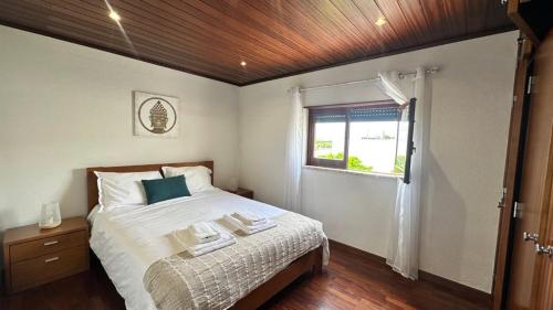 Un dormitorio con una cama grande y una ventana. en Chloe's Beach House, en A dos Cunhados