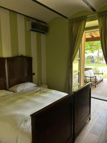 a bedroom with a large bed and a sliding glass door at Lagotto House-Apartment in the Langhe in Novello
