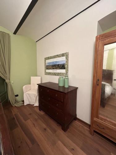 a room with a dresser and a chair in it at Lagotto House-Apartment in the Langhe in Novello